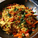 Close-up of a 3-ingredient ramen stir-fry with carrots and green onions in a pan. The easy 3-ingredient ramen stir-fry.