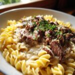 Close-up of Classic Beef Stroganoff with Egg Noodles, creamy sauce, and fresh herbs.