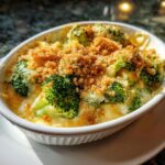Close-up of a baked Broccoli Cheese Casserole in a white dish, topped with breadcrumbs.