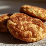 Close-up of three delicious Brown Butter Snickerdoodle Christmas Cookies sprinkled with cinnamon sugar.
