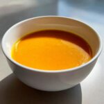 A bowl of vibrant Carrot Ginger Detox Soup, a healthy and delicious soup.