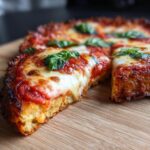 Close-up of a slice of Cauliflower Crust Margherita Flatbread with fresh basil.