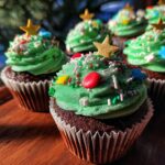Close-up of decorated Christmas Tree Cupcakes for Kids, with green frosting, sprinkles, and star toppers.