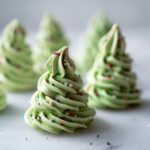 Close-up of green Christmas Tree Meringue Pops decorated with sprinkles, perfect for the holidays.