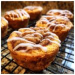 Close-up of freshly baked Cinnamon Roll Sugar Cookie Cups with icing and cinnamon sugar.