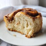 Close-up of a slice of Cloud Bread Cinnamon Rolls on a white plate, showing the fluffy texture and cinnamon swirl.