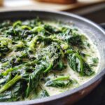 Close-up of Creamed Spinach in a skillet, showing the creamy sauce and fresh spinach.