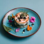 A beautifully presented dish, possibly a seafood or vegetable terrine, garnished with edible flowers and herbs, perfect for DIY candle gifts with essential oils.