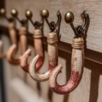 Close-up of rustic, handmade DIY stocking hangers for fireplace, featuring wooden hooks with twine and brass accents.