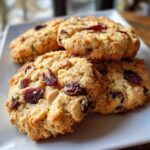 Close-up of Easy 3-Ingredient Christmas Cookies studded with dried cranberries and almonds on a white plate.