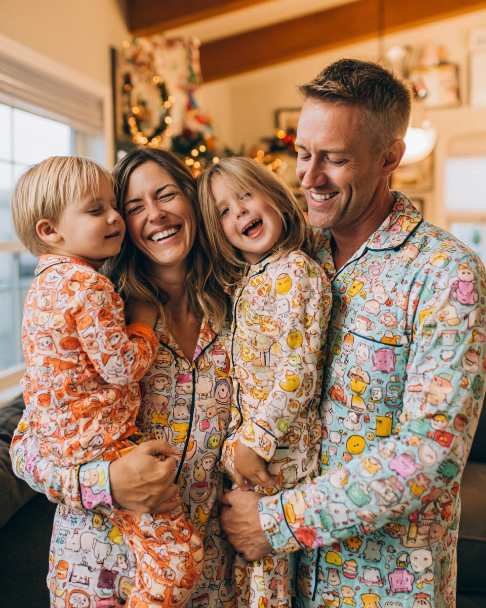 A joyful family of four wearing matching cartoon-themed pajamas, sharing a laugh in a cozy setting.