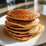 Stack of fluffy Gingerbread Pancakes drizzled with syrup, a delicious breakfast. Featuring the primary keyword: Gingerbread Pancake Stack.