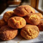A close-up pile of freshly baked Gingerdoodle Cookies, coated in cinnamon sugar, with a soft, chewy texture.