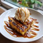 Grilled Pineapple Caramel Sundae topped with vanilla ice cream and caramel sauce, a delicious dessert.
