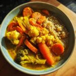 A bowl of Immune-Boosting Turmeric Veggie Soup with carrots, cauliflower, broccoli, and quinoa.