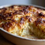Close-up of a golden-brown baked Leek Gratin in a ceramic baking dish.