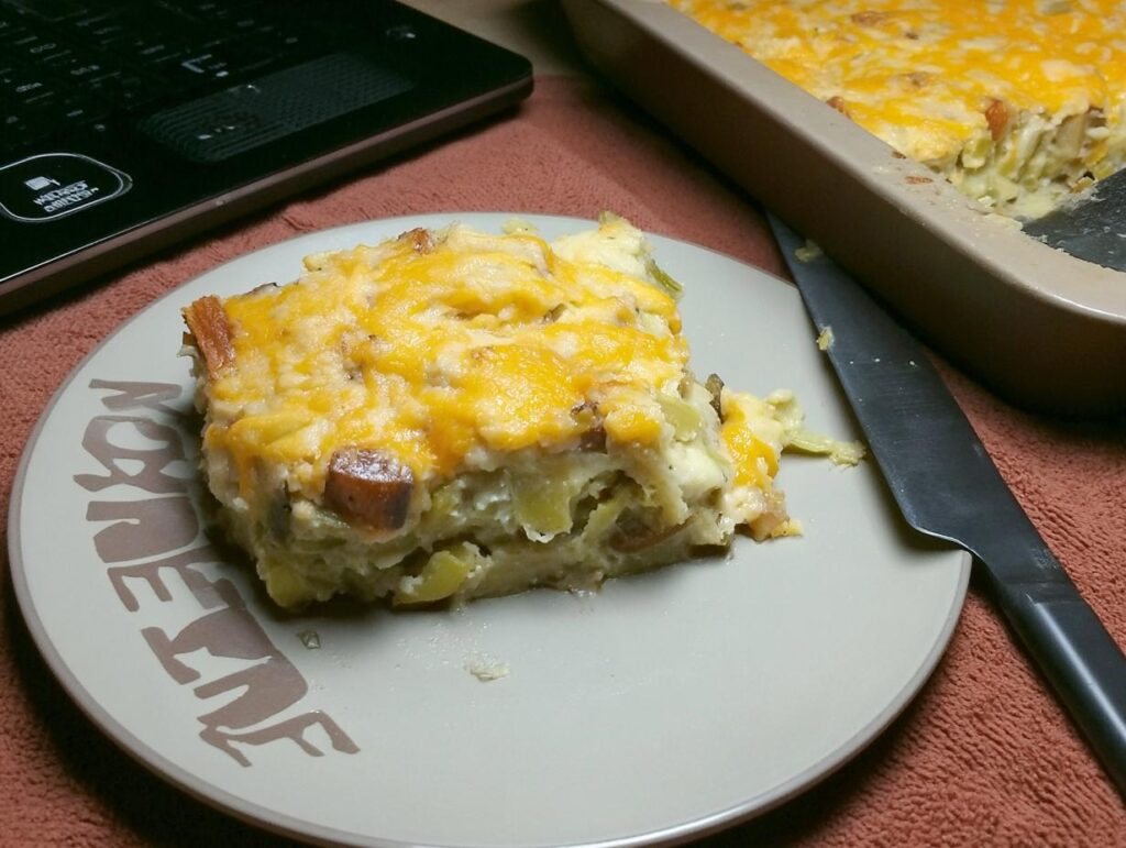 A slice of golden-brown Leek Gratin on a plate, ready to be enjoyed. A comforting dish.