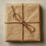 A rectangular gift box wrapped in minimalist kraft paper and tied with twine.