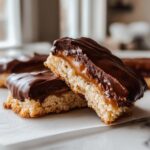 Close-up of a North Pole Chocolate-Dipped Shortbread Bar, showing layers of shortbread, caramel, and chocolate.