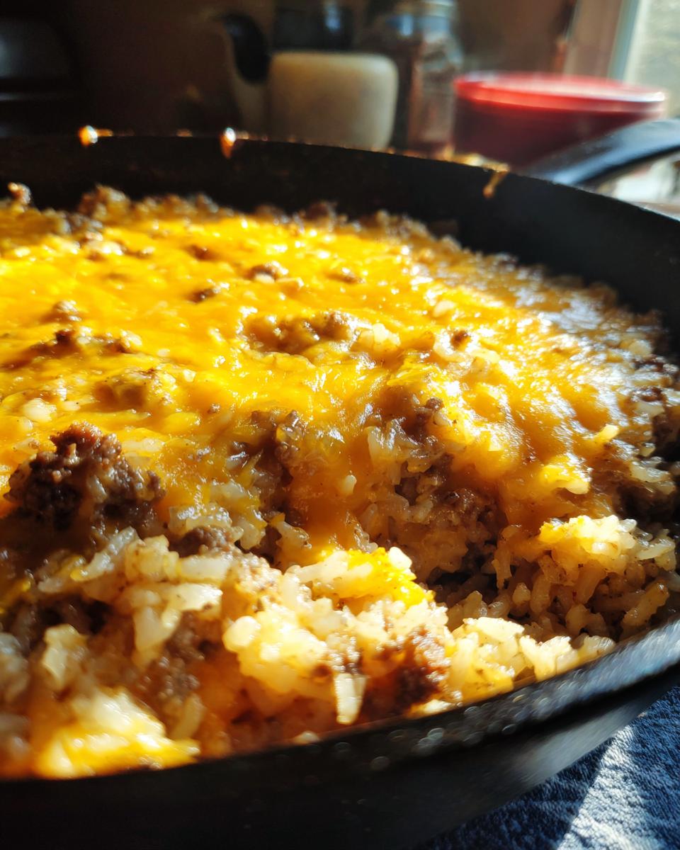 Close-up of a One-Pot Cheesy Beef and Rice Skillet, with melted cheese topping.
