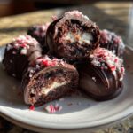 Close-up of Peppermint Bark Stuffed Oreo Balls, showing the creamy filling and peppermint topping.