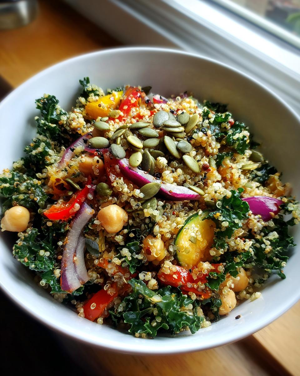 Close-up of a colorful Quinoa Kale Power Bowl with quinoa, kale, chickpeas, and pumpkin seeds.