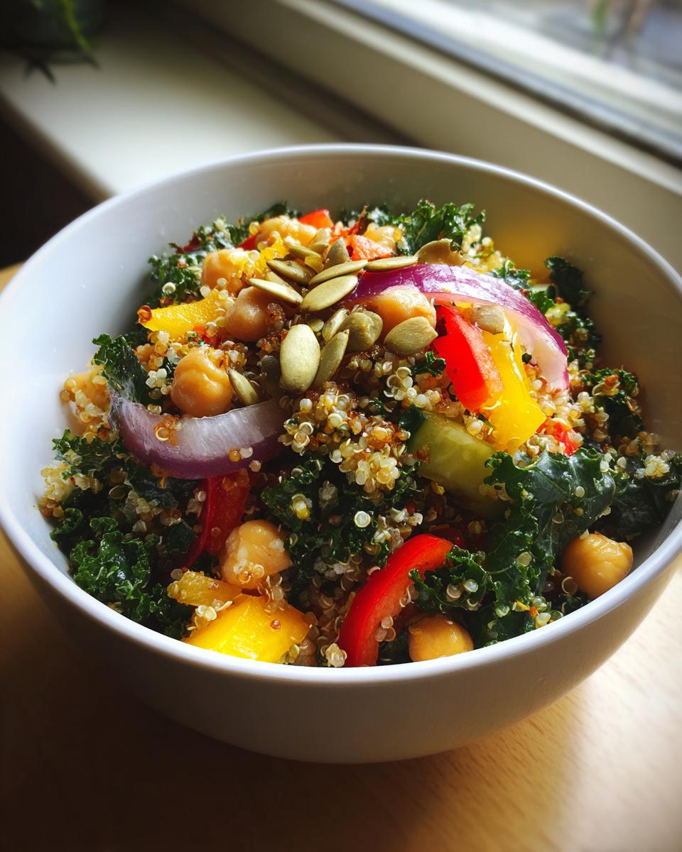 Close-up of a Quinoa Kale Power Bowl with chickpeas, red onion, and pumpkin seeds.