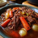 Close-up of a Rustic Red Wine Pot Roast with carrots, onions, and tender beef.
