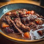 Close-up of a bowl of Rustic Red Wine Pot Roast, showing tender meat and rich gravy.