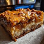 Close-up of a Salted Caramel Pretzel Blondie slice, showing caramel, pretzels, and nuts.
