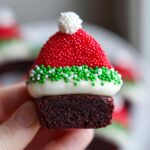 Close-up of a Santa Hat Brownie Bite, a festive treat with red sprinkles and white frosting.