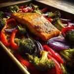 Sheet pan turmeric salmon with roasted broccoli, red peppers, and red onion.