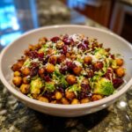 Bowl of Spicy Roasted Chickpeas Brussels Sprout Salad with cranberries and parmesan.