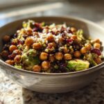 A bowl of Spicy Roasted Chickpeas Brussels Sprout Salad with cranberries and parmesan.