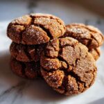 A stack of Starbucks Copycat Ginger Molasses Cookies, coated in sparkling sugar, with cracked surfaces.