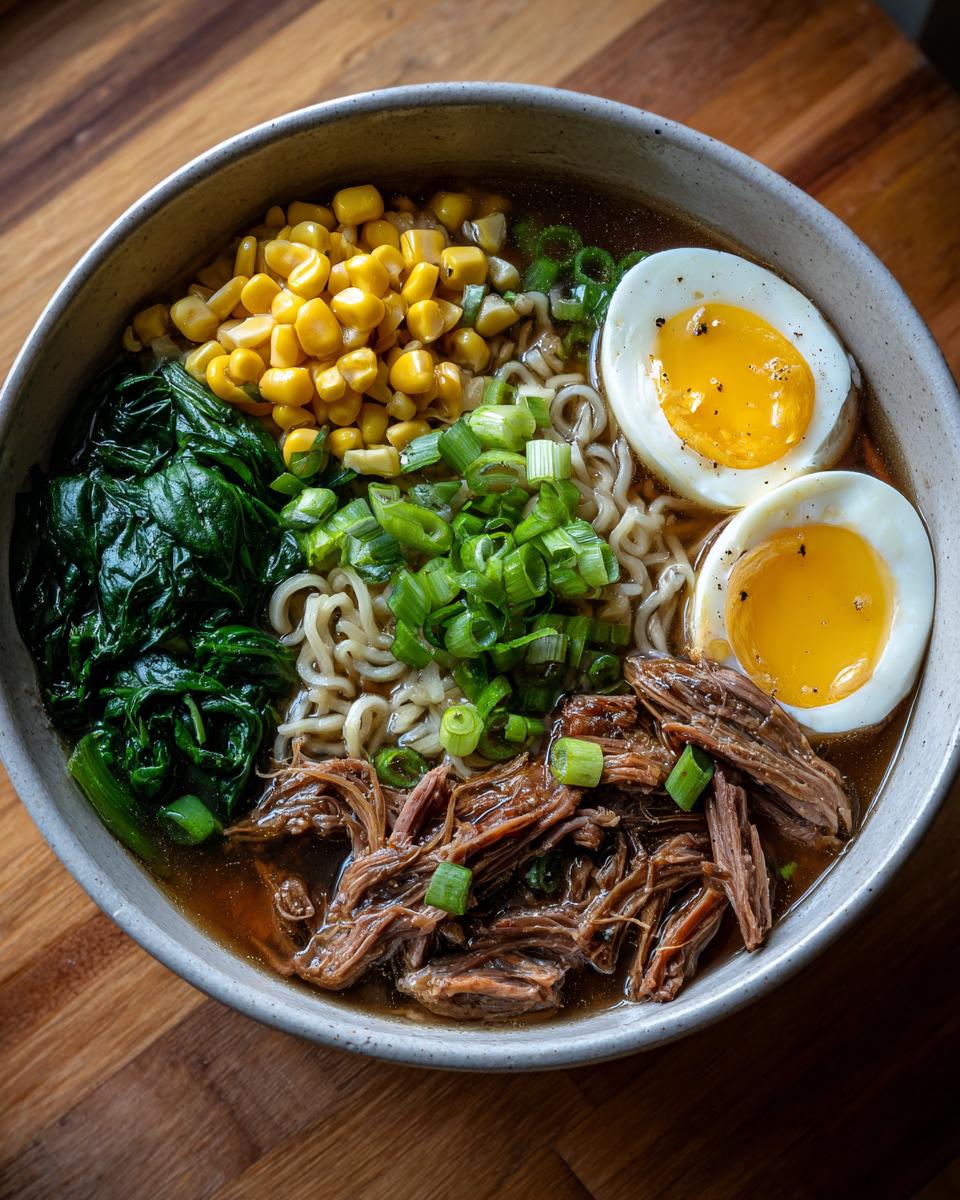 Overhead shot of an Upgraded Ramen Bowl with Garlic Butter, featuring noodles, egg, meat, and vegetables.