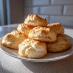 A stack of golden-brown Whipped Shortbread Cookies on a white plate, ready to be enjoyed.