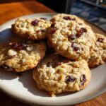 A plate of freshly baked White Chocolate Cranberry Oatmeal Cookies, with white chocolate chips and dried cranberries.