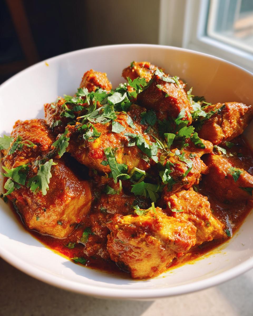 Close-up of Chicken Curry With Coconut Milk in a white bowl, garnished with cilantro.