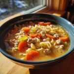 Close-up of a bowl of Ground Turkey Soup with noodles, carrots, and celery.