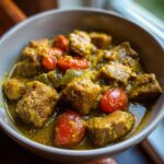 Close-up of a bowl of delicious Pork Green Chili with tomatoes and peppers.