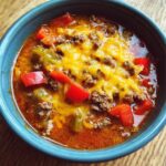 Close-up of a bowl of Stuffed Pepper Soup with ground beef, peppers, and melted cheese.