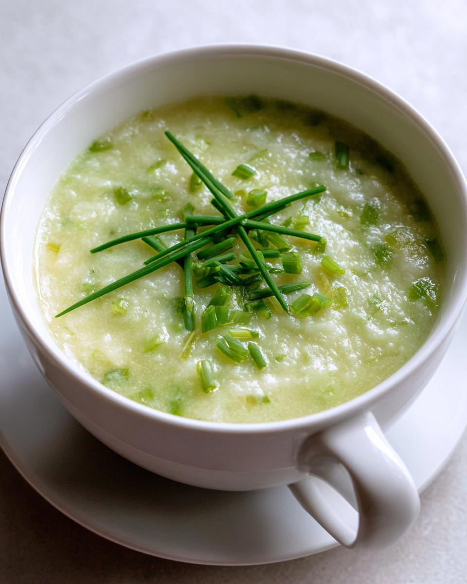 A bowl of creamy Vegetarian Colcannon Soup, garnished with fresh chives.
