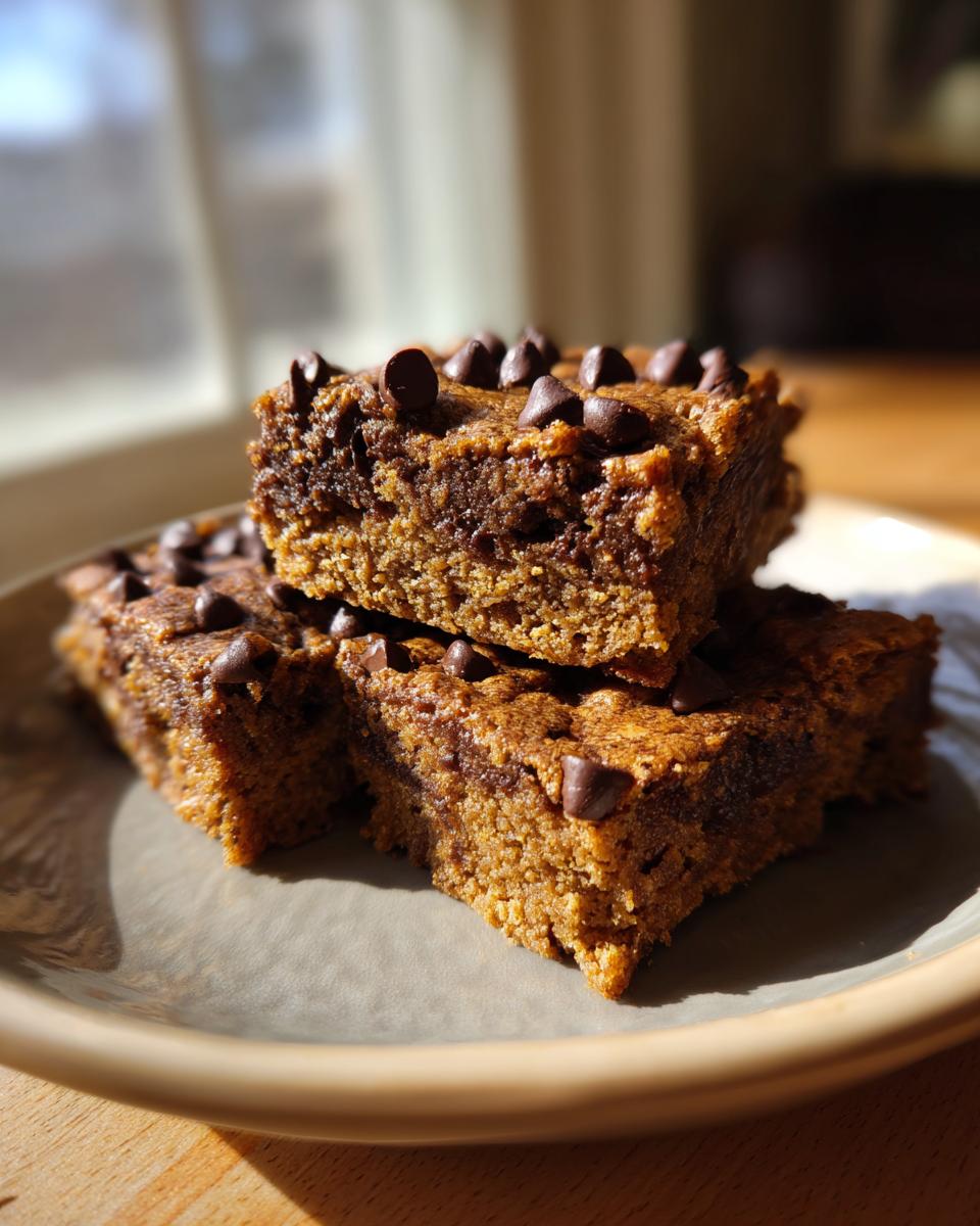 Close-up of three bars, better than brownies, topped with chocolate chips on a plate.