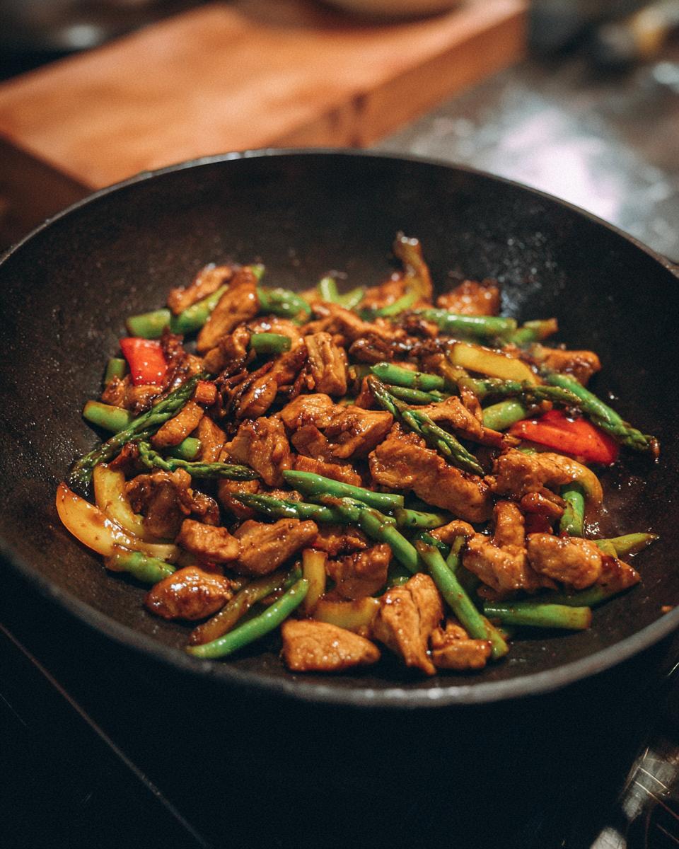 Easy Chicken Stir Fry: 35 Min Savory Delight 3 Close-up of Easy Chicken Stir Fry with chicken, asparagus, and peppers in a wok.