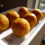Close-up of several golden Anti-Inflammatory Cat Treats on a white plate, perfect for feline health.