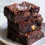 Stack of Crispy-Edge Fudgy Brownie Bars with Salted Toffee on a white plate.