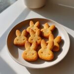 Overhead shot of a plate with several Easter Bunny-Shaped Cat Treats, golden brown and ready to eat.