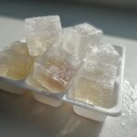 Close-up of frozen tuna cat treat cubes in a white ice cube tray, perfect for a cat.