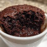 Close-up of a fudgy microwave brownie in a white mug. Perfect for an Easy Recipe: Make a Fudgy Microwave Brownie.